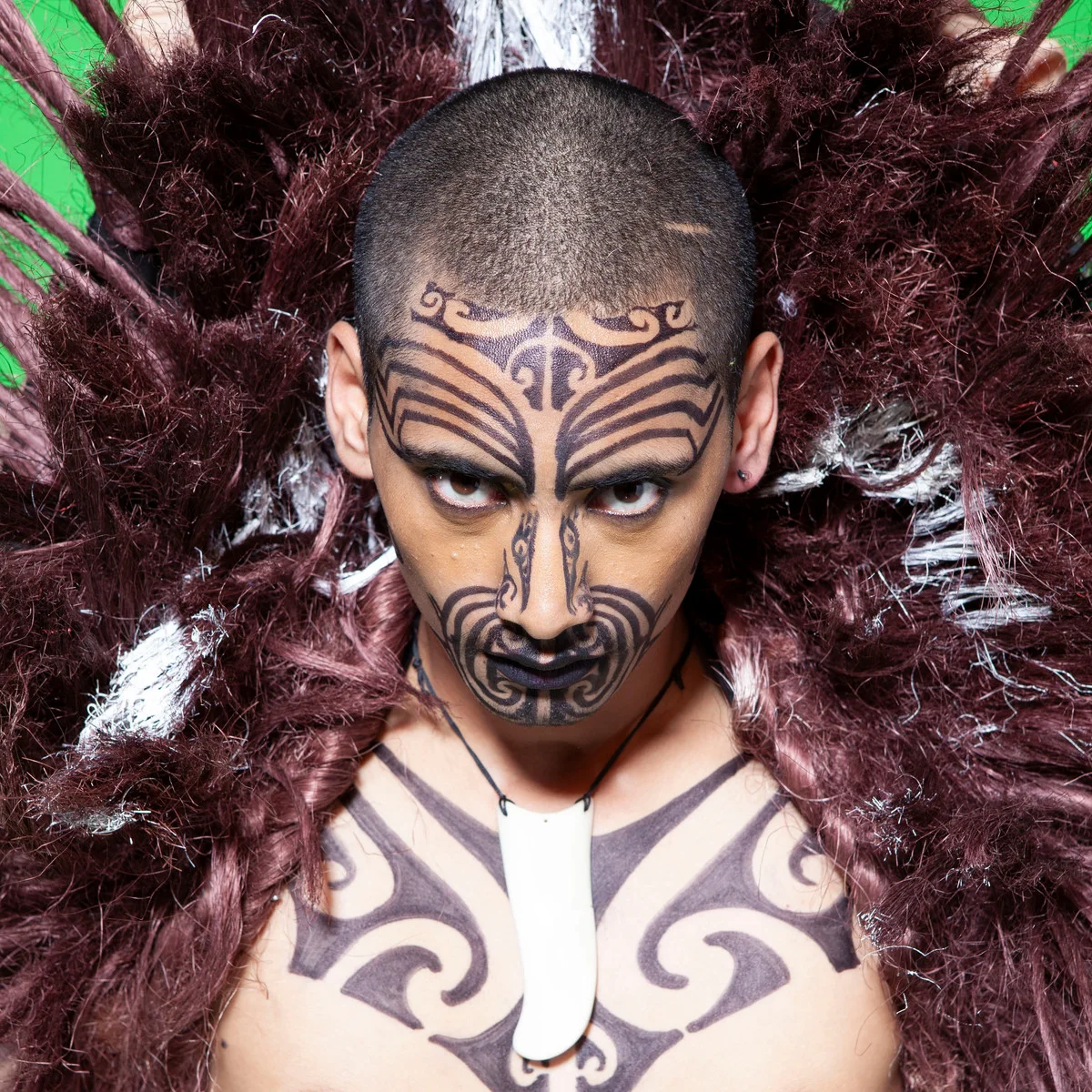 Māori performance artist in a feathered costume
