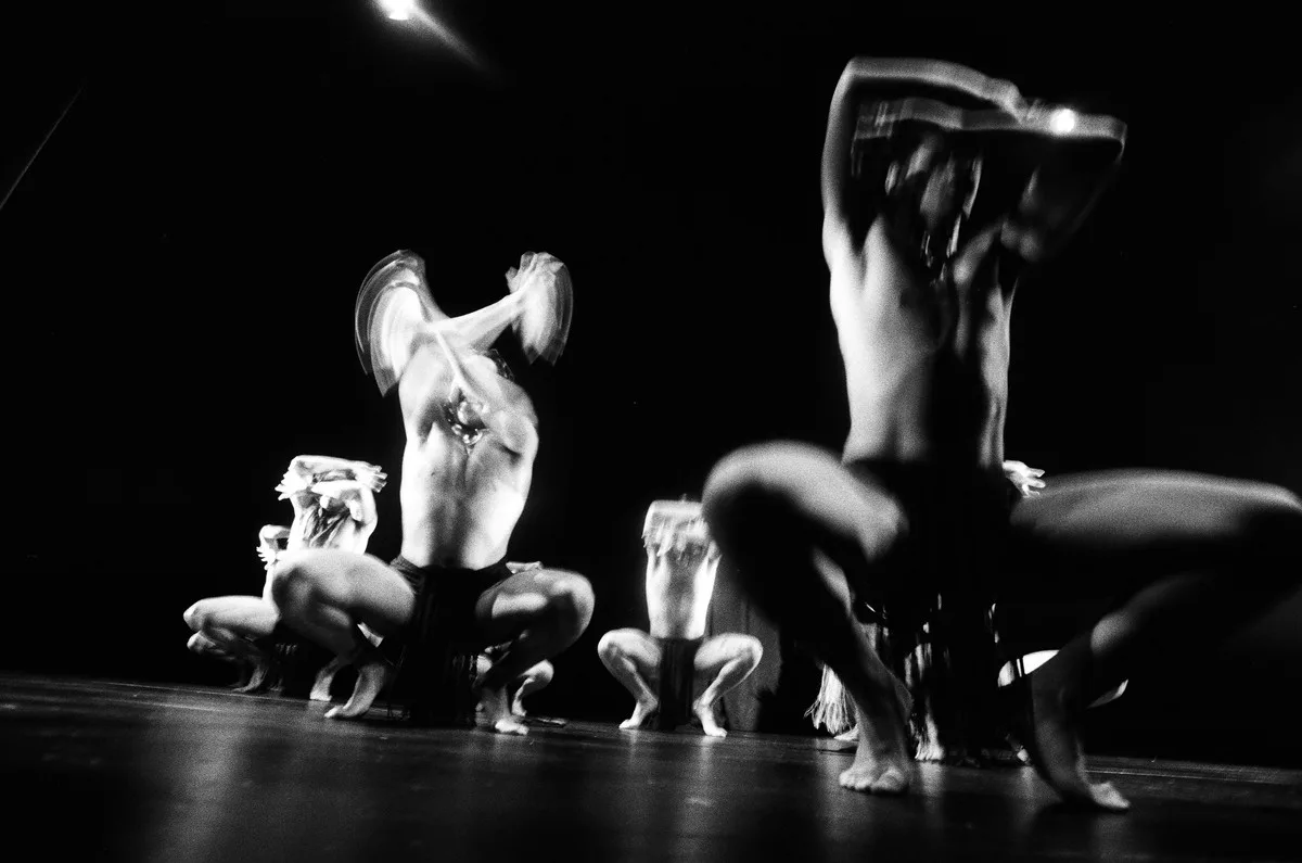 Layered photographic artwork showing performers in an urban night scene