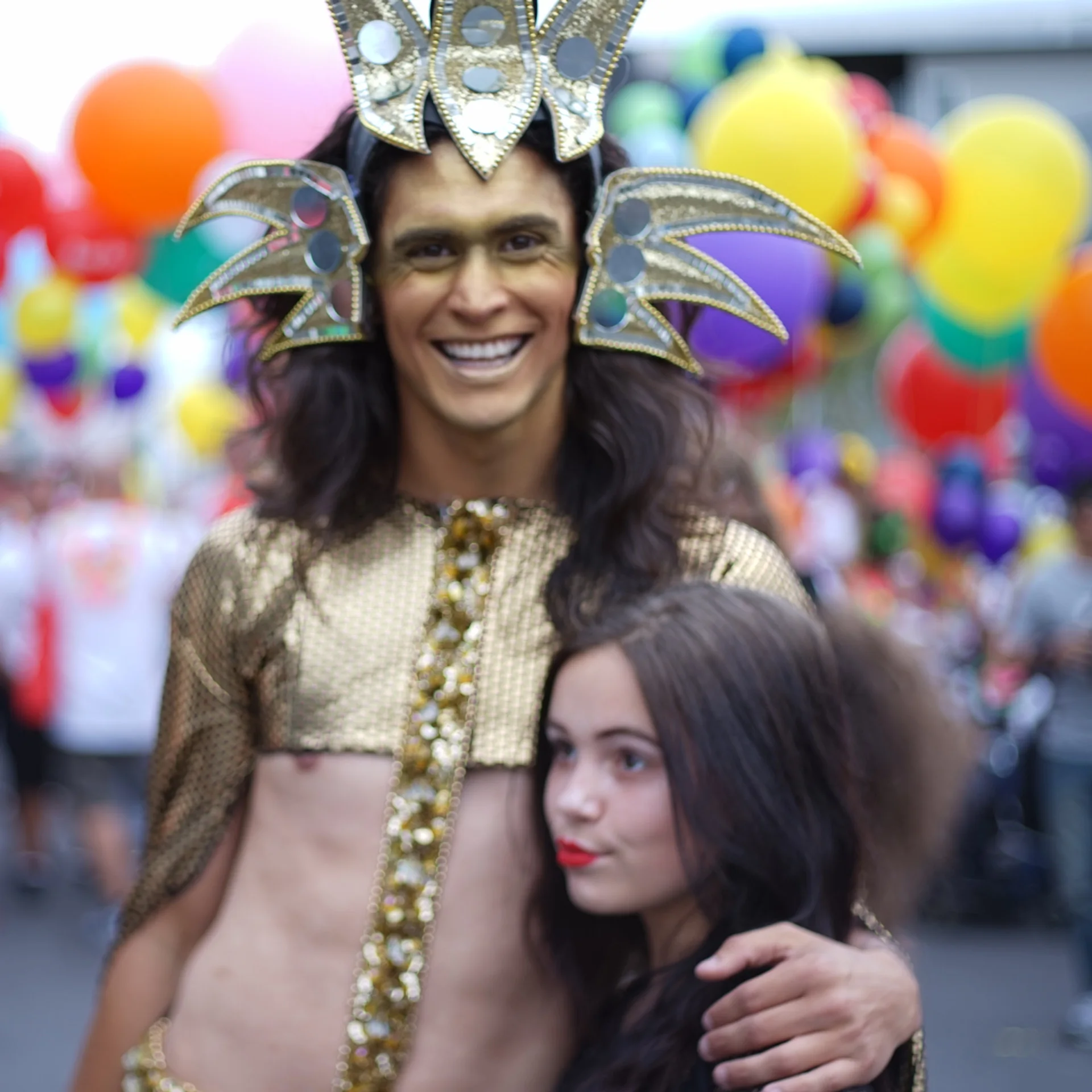A Māori performer in gold costume at a Pride celebration